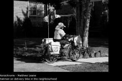 Postman on delivery bike in the neighbourhood - Matthew Leane